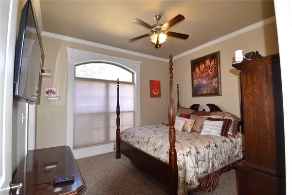 a bedroom with a bed a window and a chandelier