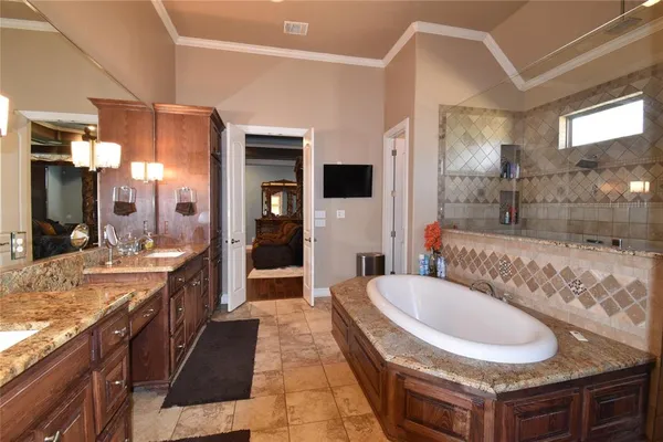 a spacious bathroom with a granite countertop tub sink and mirror