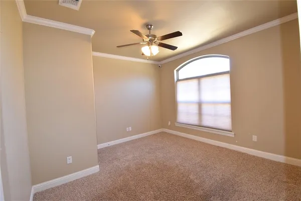 an empty room with windows and fan