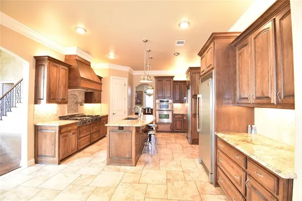 a large kitchen with kitchen island granite countertop a large counter top appliances and cabinets