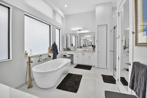 a bathroom with a bathtub sink shower and mirror