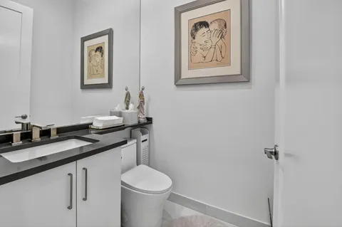 a bathroom with a granite countertop sink mirror and toilet