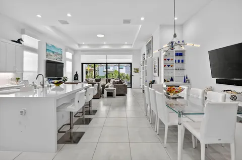 a large white kitchen with lots of counter space and chandelier