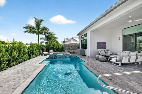 a view of a backyard with couches table and chairs with potted plants