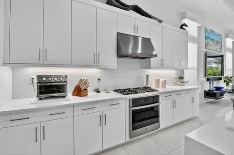 a kitchen with white cabinets and appliances