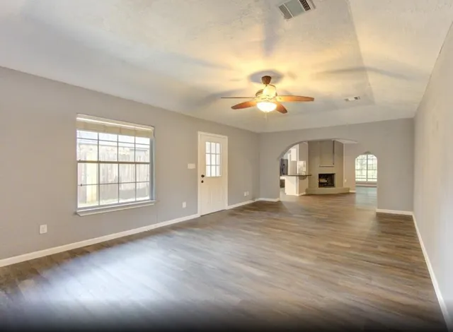 a view of empty room with a window and fireplace