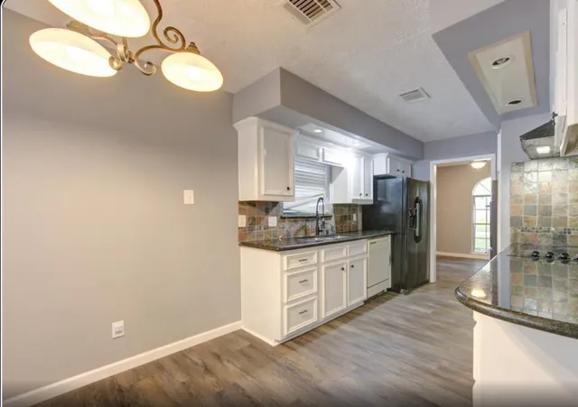 a kitchen with stainless steel appliances granite countertop a sink and cabinets