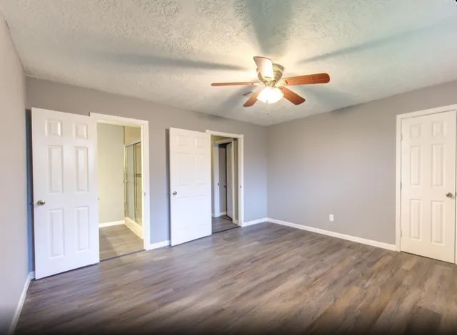 a view of an empty room with window and a kitchen