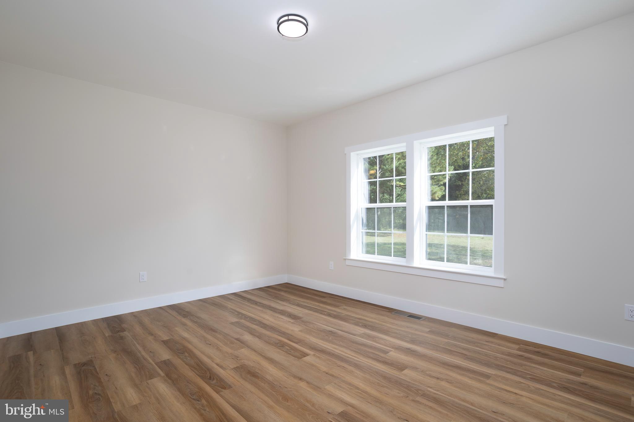 Clark Corner Road Centreville, MD 21617 - Photo 11 of 43 an empty room with wooden floor and windows