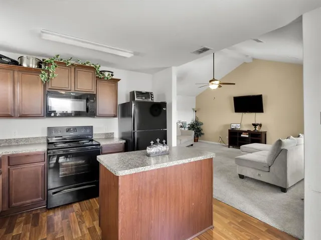 a kitchen with stainless steel appliances a stove a sink dishwasher a refrigerator and a microwave