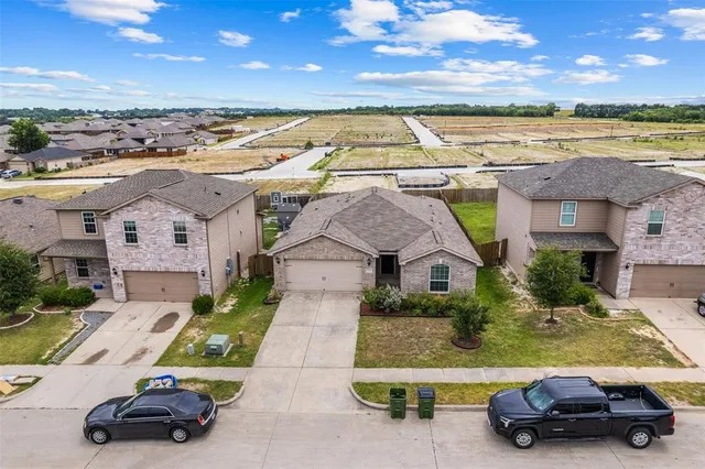 an aerial view of a house with a garden and car parked
