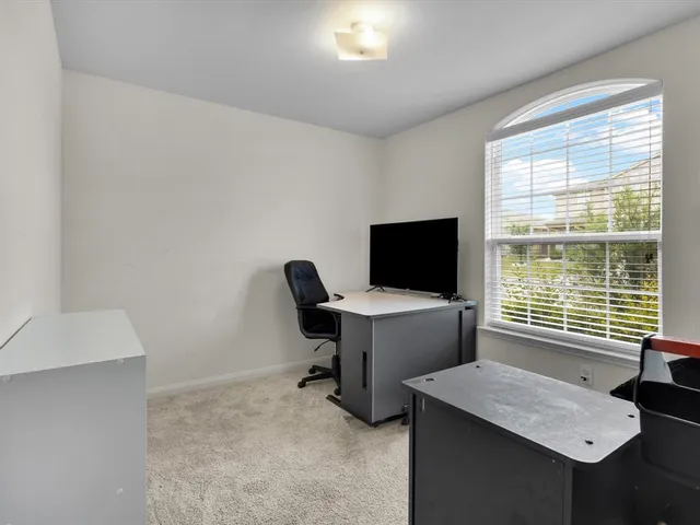a view of a workspace with furniture and a window