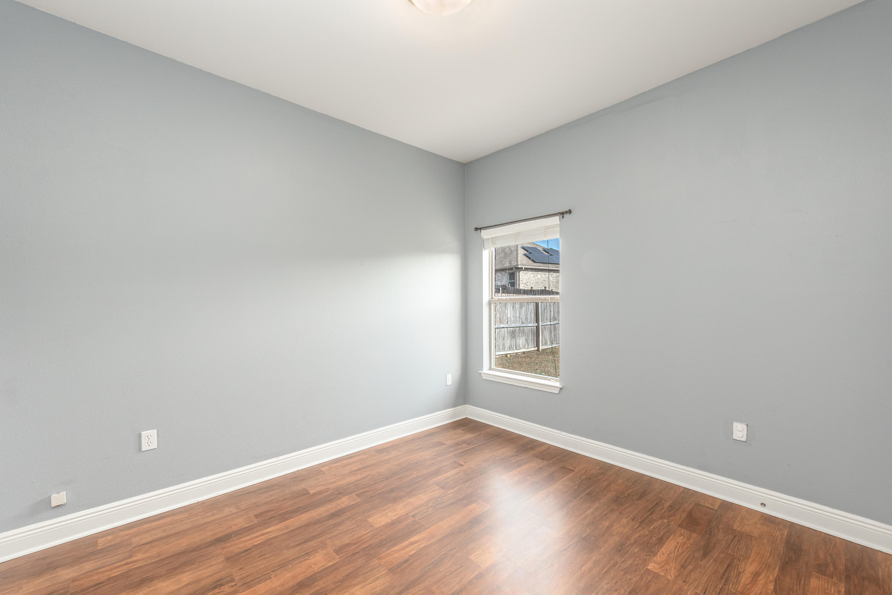 606 Rowan Circle Crestview, FL 32536 - Photo 10 of 24 an empty room with wooden floor and windows