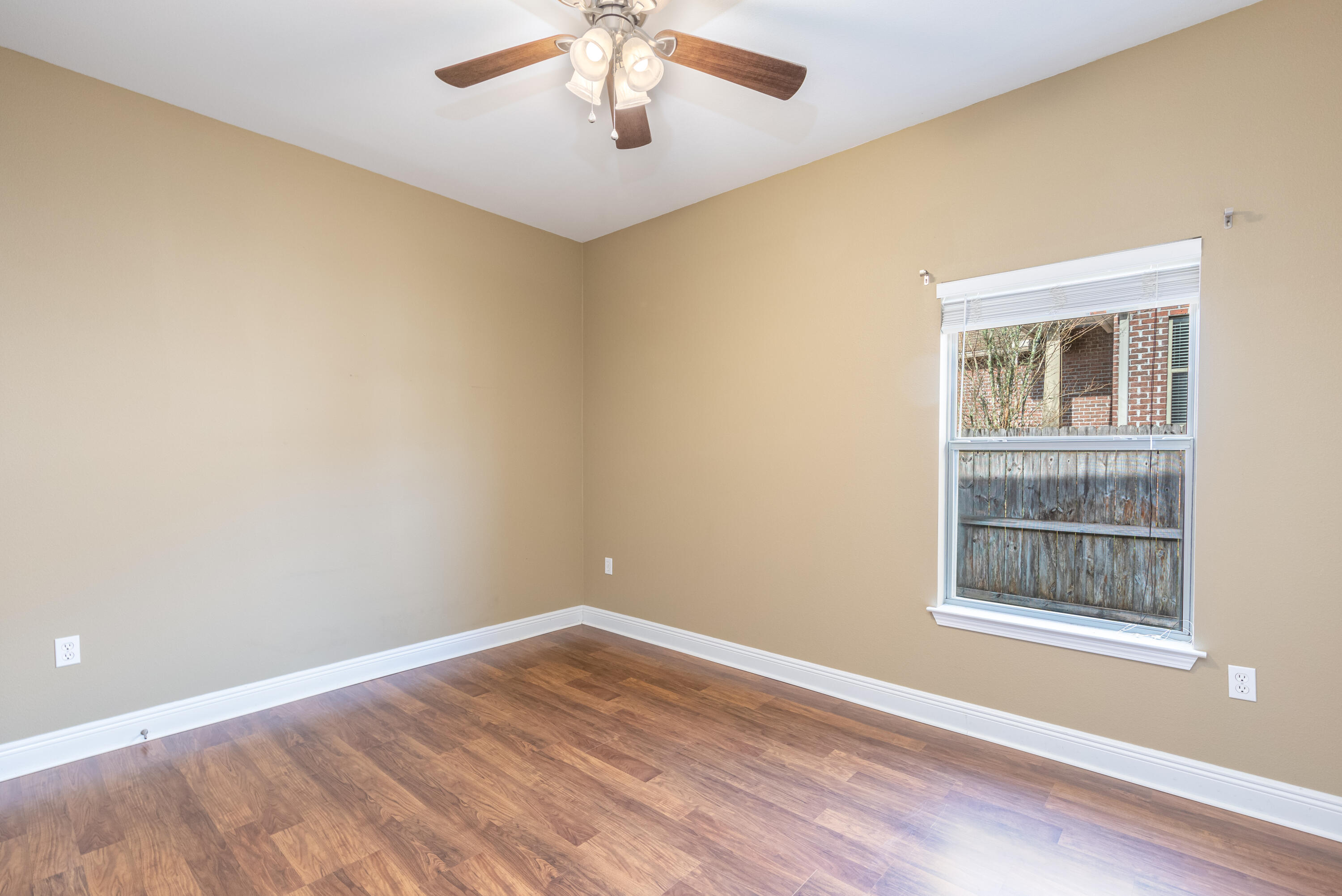 606 Rowan Circle Crestview, FL 32536 - Photo 13 of 24 a view of an empty room with a window and wooden floor