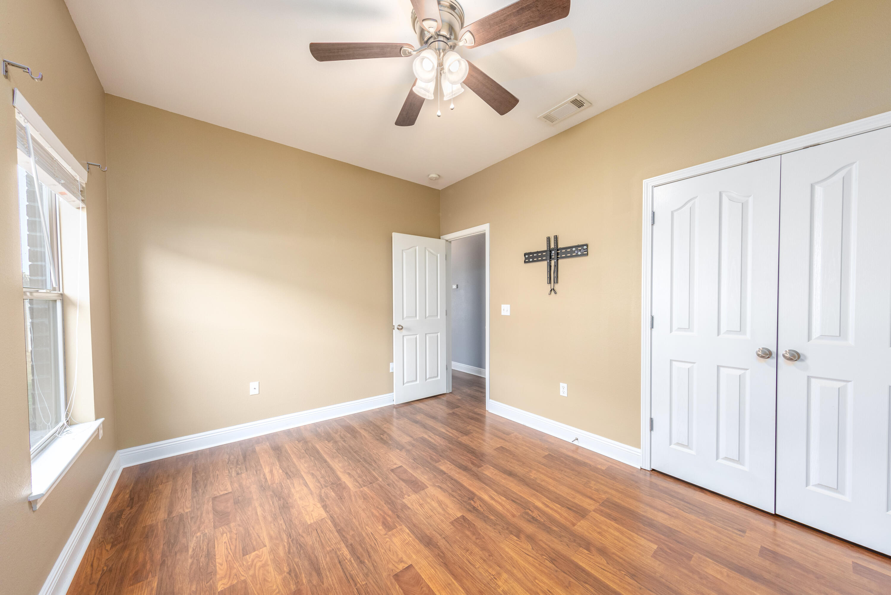 606 Rowan Circle Crestview, FL 32536 - Photo 14 of 24 wooden floor in an empty room with a window