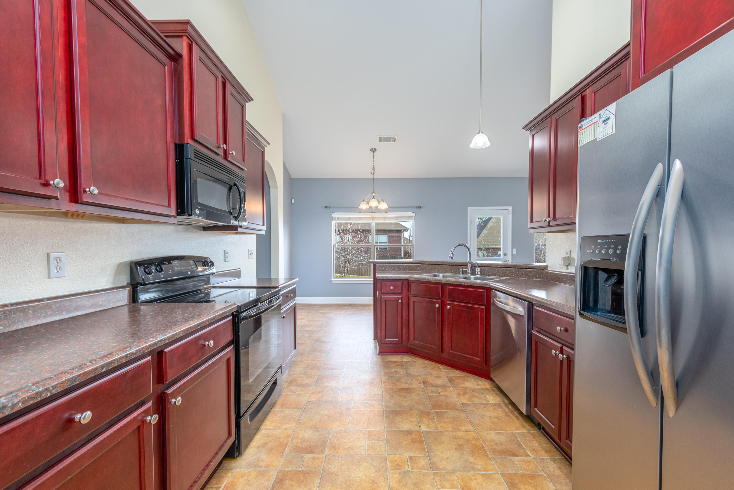 606 Rowan Circle Crestview, FL 32536 - Photo 6 of 24 a large kitchen with stainless steel appliances granite countertop a stove a sink dishwasher a refrigerator and a microwave oven