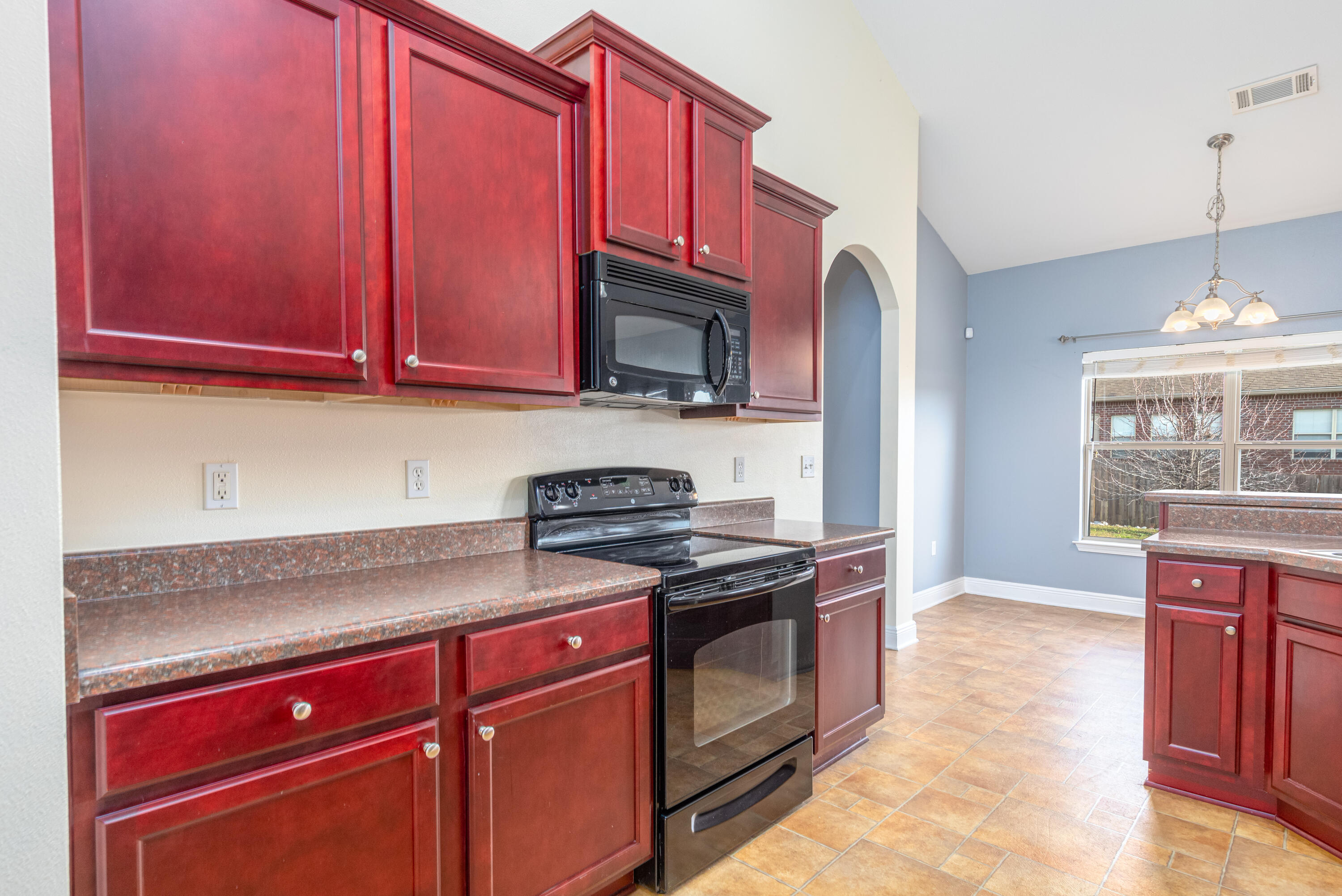606 Rowan Circle Crestview, FL 32536 - Photo 7 of 24 a kitchen with granite countertop a stove top oven microwave and cabinets