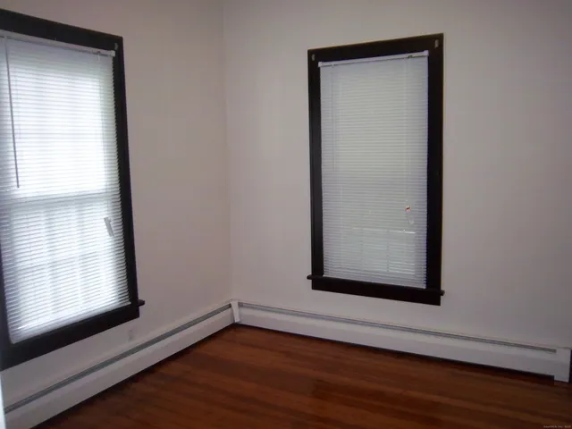 a view of a small space with wooden floor and a window