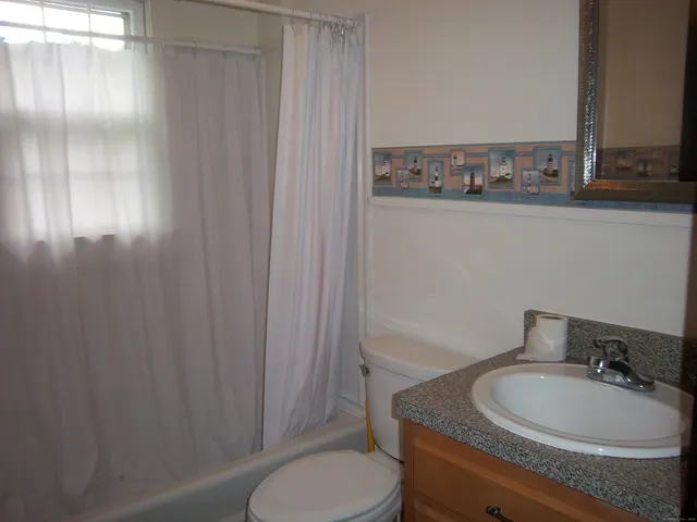 a bathroom with a toilet a sink and mirror