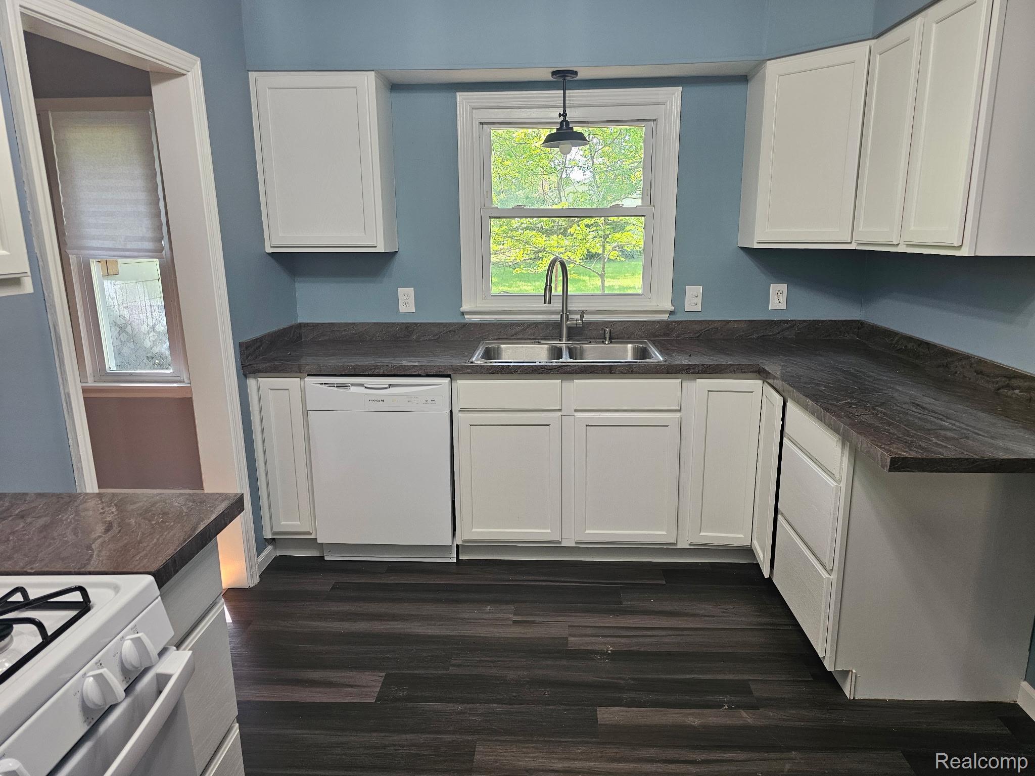1260 Gilbert Street Flint, MI 48532 - Photo 11 of 32 Kitchen featuring white cabinetry, dark wood-finish flooring, a double basin stainless steel sink with a gooseneck faucet, and dark countertops