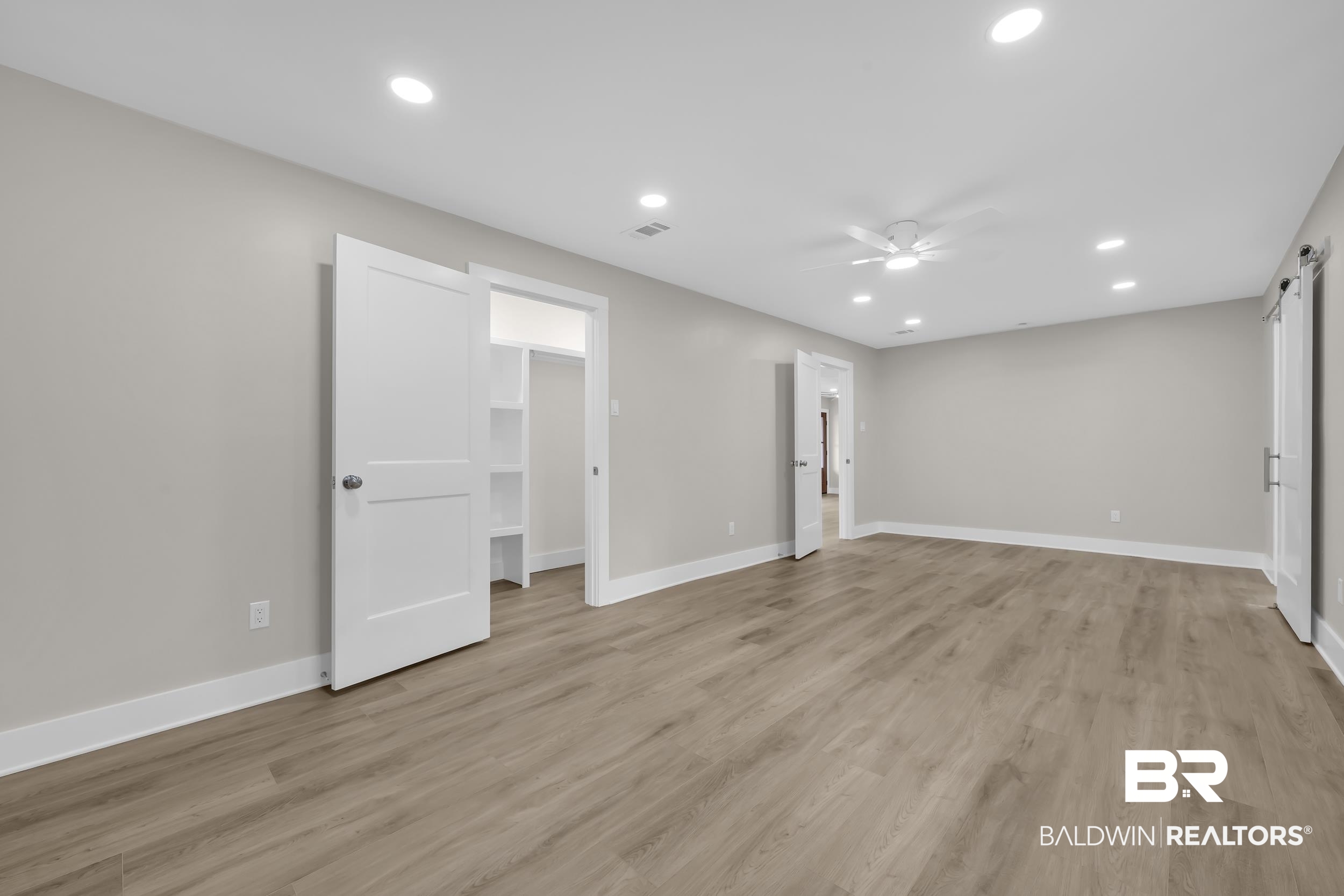 11381 Normandy Drive East Semmes, AL 36575 - Photo 10 of 23 Unfurnished bedroom featuring recessed lighting, a walk in closet, light wood finished floors, a barn door, and ceiling fan