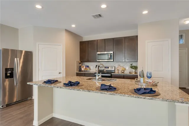 a kitchen with sink a refrigerator and cabinets
