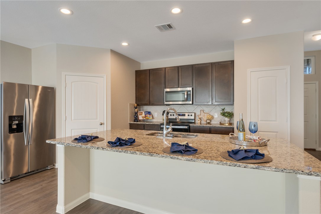 a kitchen with sink a refrigerator and cabinets