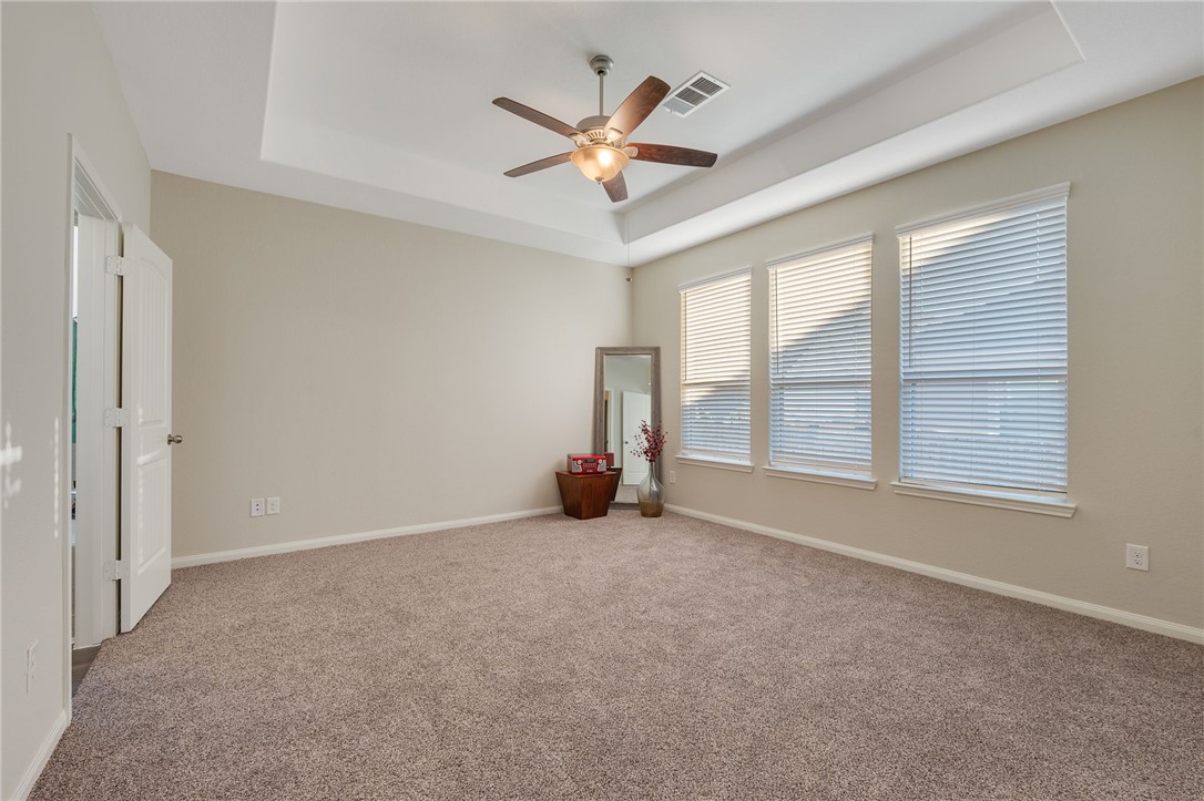4704 Los Pines Way Bryan, TX 77807 - Photo 11 of 26 a view of an empty room with chandelier fan and windows