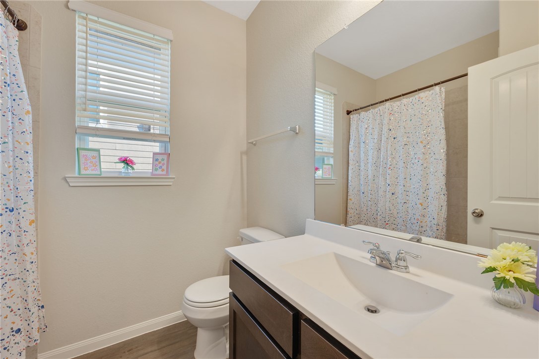 4704 Los Pines Way Bryan, TX 77807 - Photo 20 of 26 a bathroom with a sink a toilet and a mirror