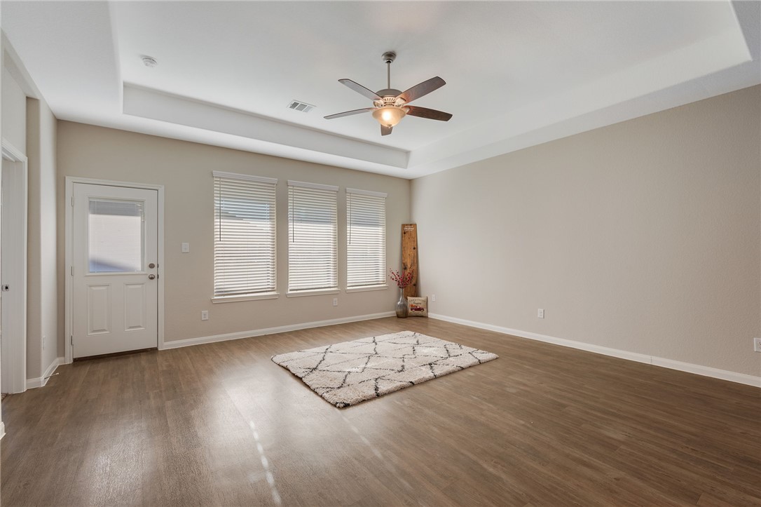 4704 Los Pines Way Bryan, TX 77807 - Photo 8 of 26 an empty room with wooden floor fan and windows