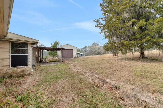 a view of a house with backyard and a tree
