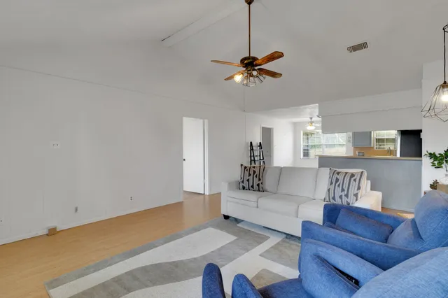 a living room with furniture and a chandelier