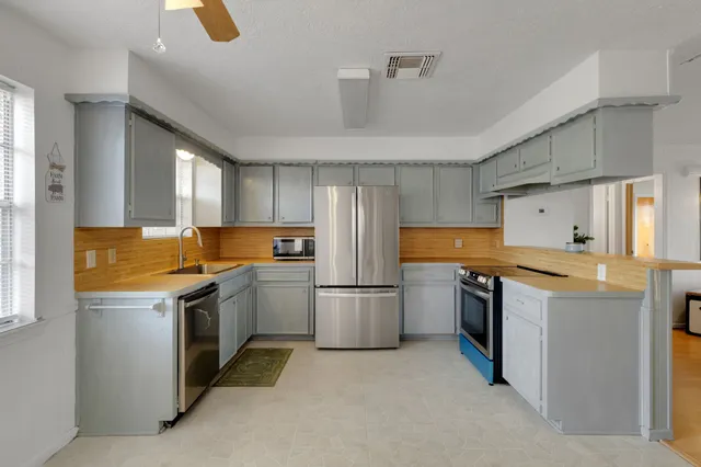 a kitchen with a stove top oven and refrigerator