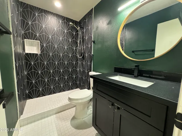 a bathroom with a sink toilet and a mirror