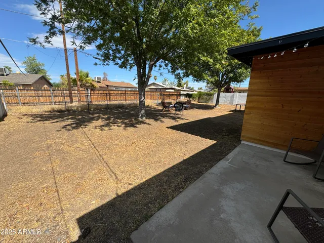 a view of a yard with wooden fence