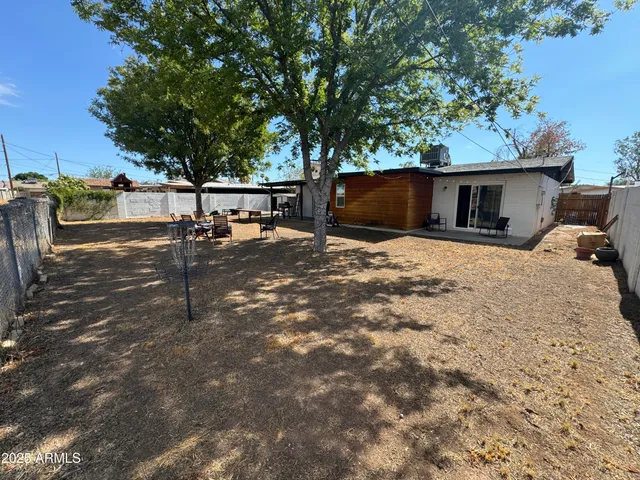 a backyard of a house with table and chairs