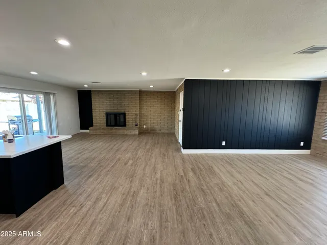 a view of a big room with wooden floor and windows