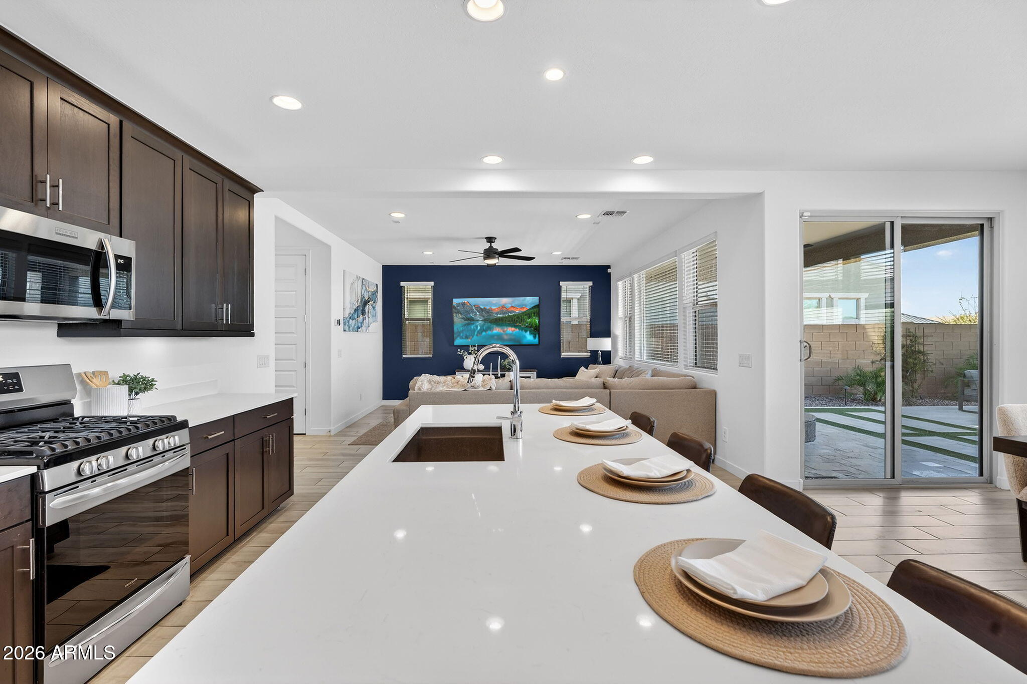 4112 East Appaloosa Road Gilbert, AZ 85296 - Photo 17 of 66 a kitchen with stainless steel appliances wooden floor dining table and chairs