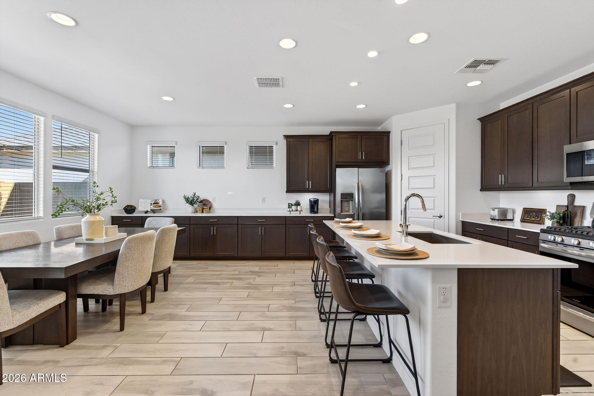 4112 East Appaloosa Road Gilbert, AZ 85296 - Photo 20 of 66 a living room with stainless steel appliances kitchen island granite countertop a stove a sink a dining table and chairs