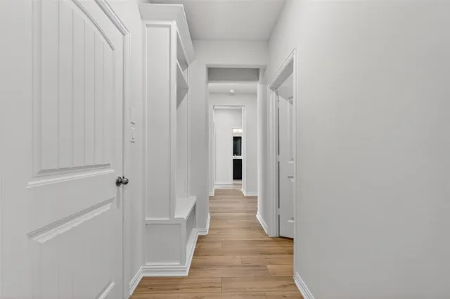 a view of a hallway with wooden floor and staircase