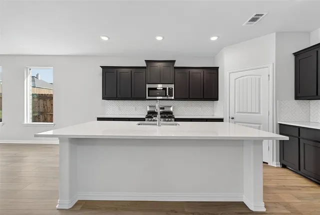 a kitchen with stainless steel appliances a sink stove and microwave