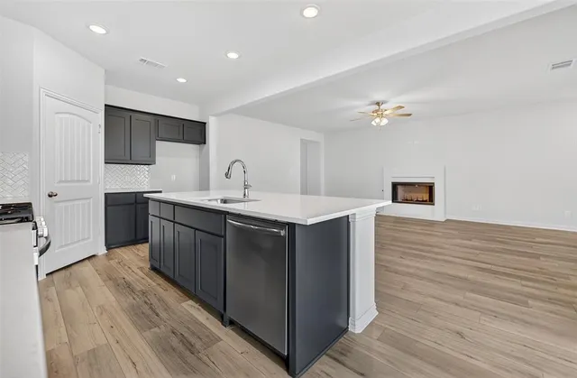 a kitchen with a sink cabinets and wooden floor