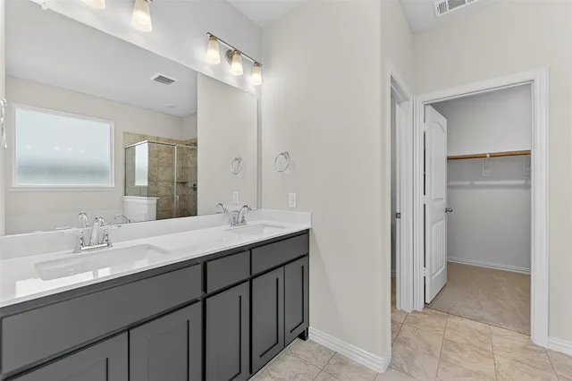 a bathroom with a double vanity sink a mirror and a shower