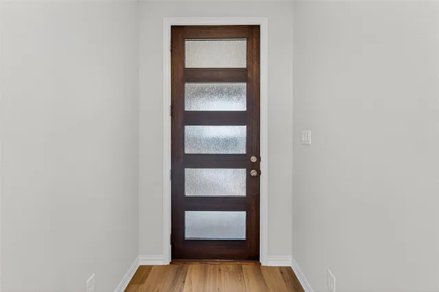 a view of an empty room with wooden floor and closet