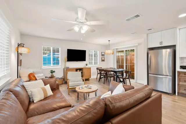 a living room with furniture dining table and a refrigerator