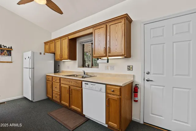 a kitchen with stainless steel appliances granite countertop a sink and a refrigerator