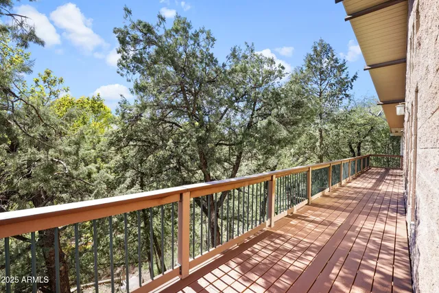 a view of a balcony with wooden floor and fence