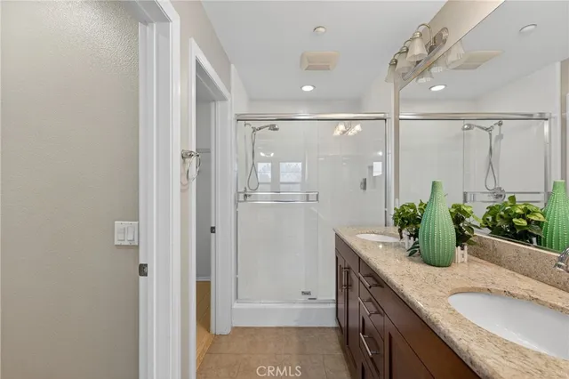 a bathroom with a granite countertop shower sink and mirror