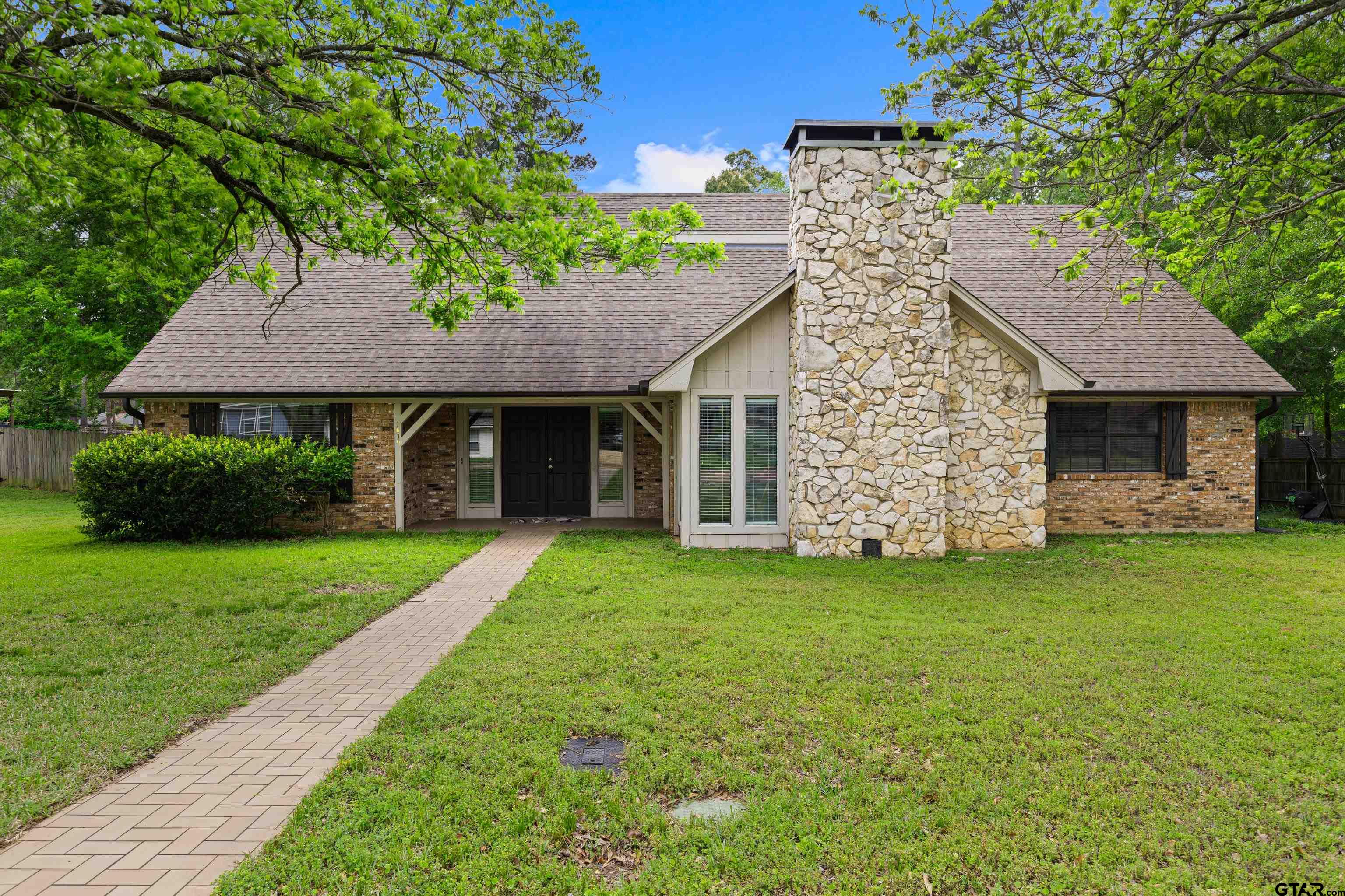 1810 Azalea Street Gilmer, TX 75644 - Photo 2 of 47 a front view of a house with a garden