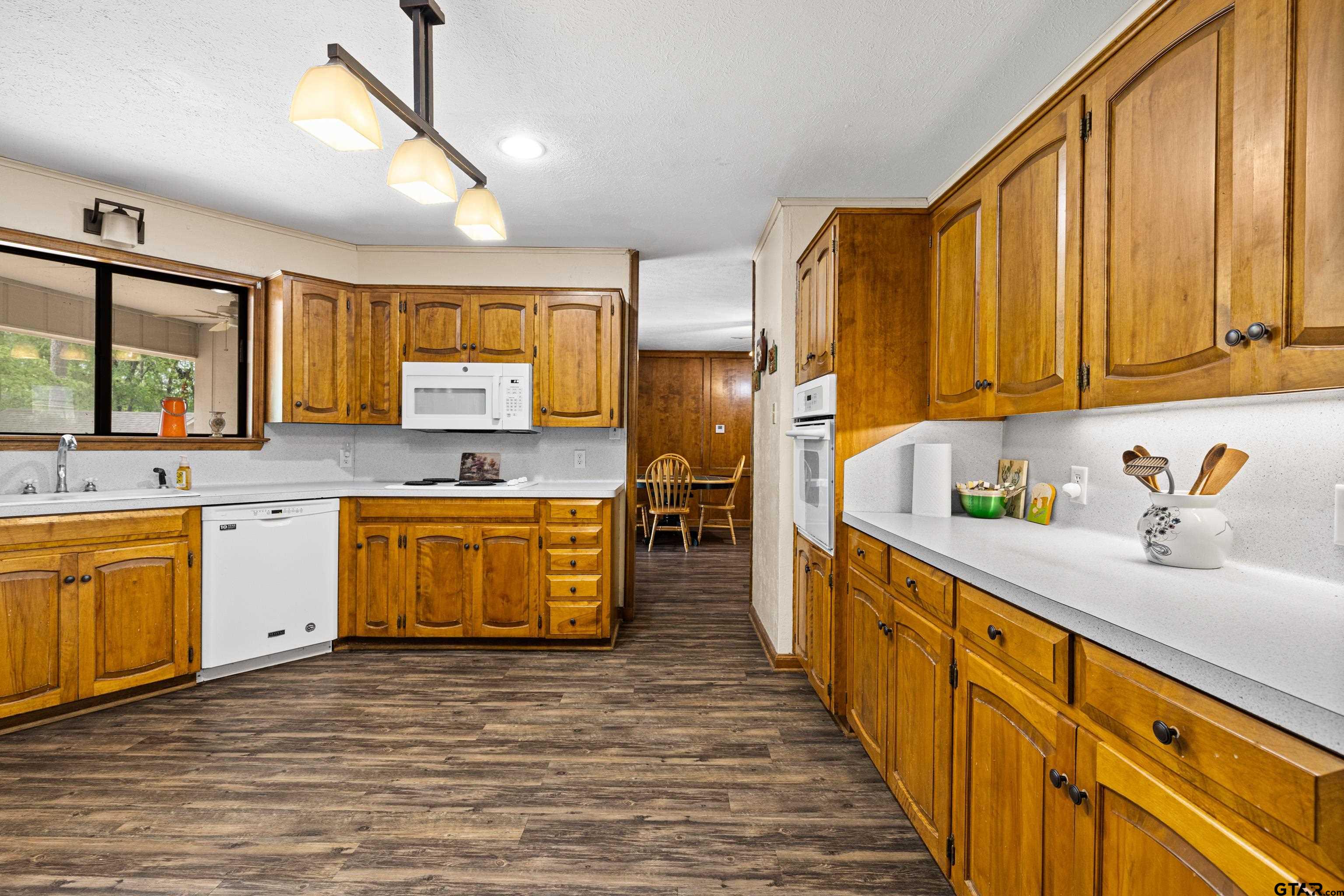 1810 Azalea Street Gilmer, TX 75644 - Photo 21 of 47 a kitchen with stainless steel appliances wooden cabinets a sink and a stove